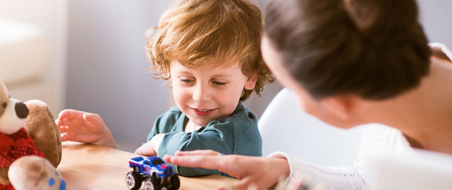 Garde d’enfants : femme en jouant avec un enfant souriant